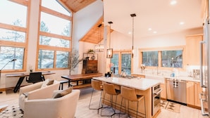Una cocina amplia con una isla grande, armarios de madera y vistas al exterior.