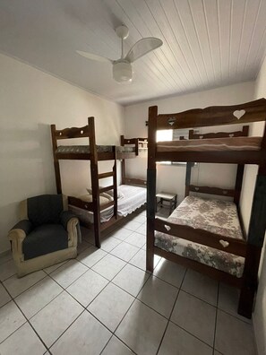 Cozy retreat with a single bed, chair, and ceiling fan.