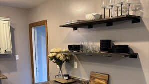 A kitchen with a granite countertop, white cabinetry, and a wooden floor. - Cowtown at Piney River Ranch; Charming Farm House in Houston, MO (Houston)