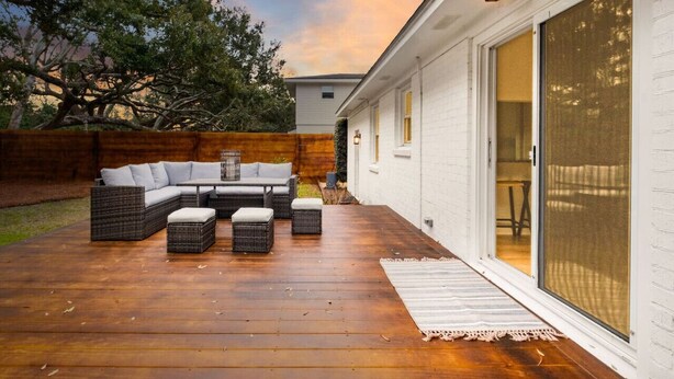 A wooden deck with a sectional sofa and ottomans, a pergola, and a sliding glass door to a covered patio. - Old Village - 3 BR with Private Backyard & Deck (Mount Pleasant)