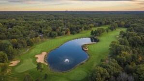 A golf course with a pond, surrounded by dense forest. - Stunning Lake Petenwell Log Home Near Sand Valley Golf (Rome)
