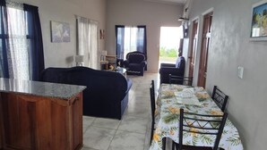 A spacious living area with a dining table, sofa, and kitchen counter. - A single-family home w/ a serene view. Nonsmoking and pet-friendly environment. (Perez Zeledon)
