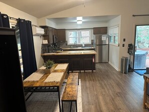 Een moderne keuken met een centraal eiland, donkere houten kasten en een roestvrijstalen koelkast.