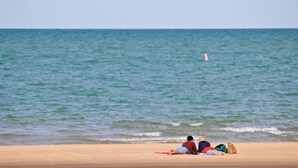 Ein Strand mit sandigem Ufer und ruhiger See.