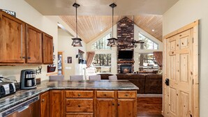 Una cocina amplia con armarios de madera, una isla grande y una chimenea de piedra.