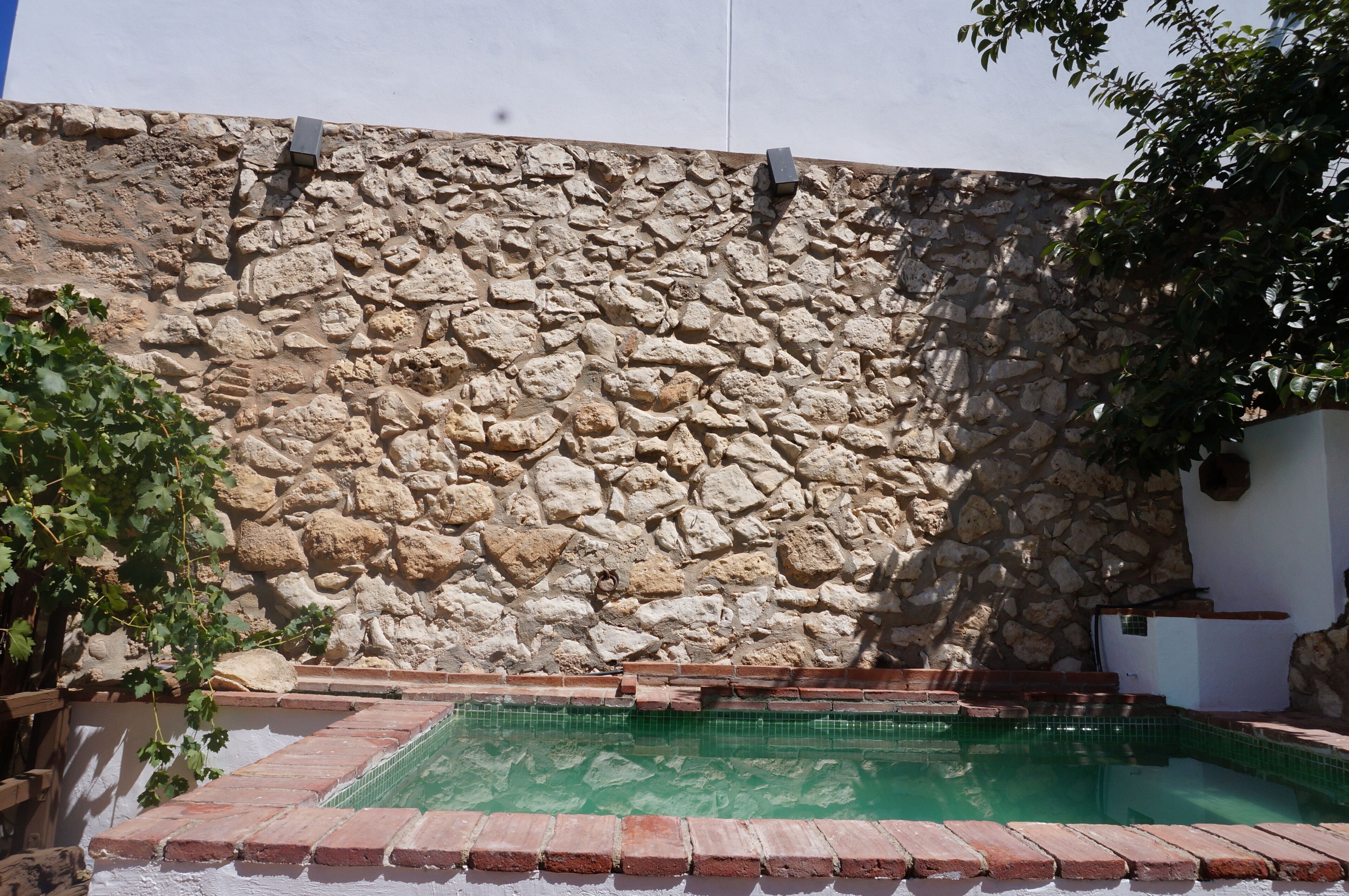 Un mur en pierre avec un espace piscine.