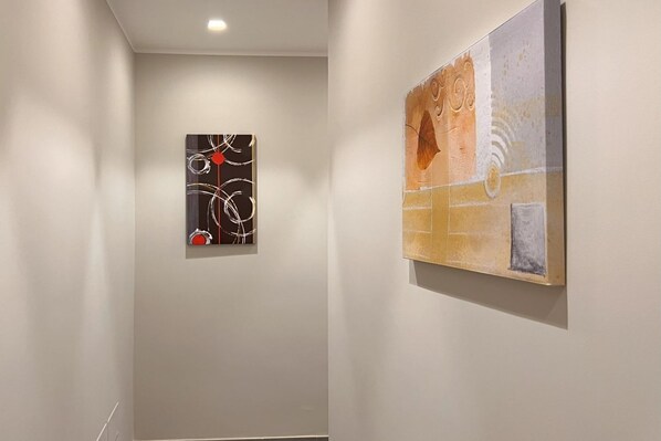 A hallway with two artworks on the walls.