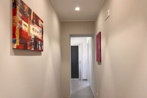 Ein Flur mit einem roten, abstrakten Gemälde links und einem rosafarbenen, abstrakten Gemälde rechts.