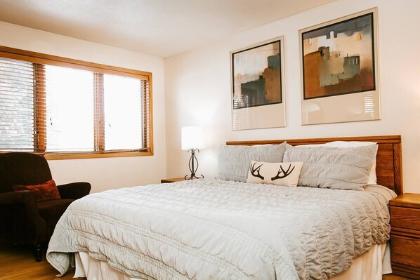 A bedroom with a large bed, a chair, a nightstand, and two framed artworks on the wall. - Just Listed! Mountain views, 5 min walk to lifts, 2-bedroom condo in Keystone (Keystone)
