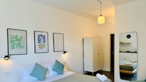 A modern bedroom with a bed, pillows, a bedside table, a wardrobe, and a mirror. - Villa Reise (Riomaggiore)