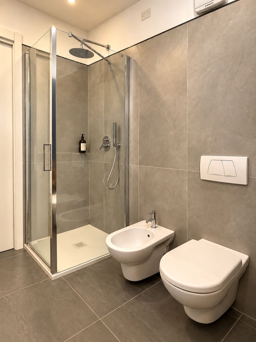 Une salle de bain moderne dotée d’une douche à parois de verre, d’un bidet et de toilettes.