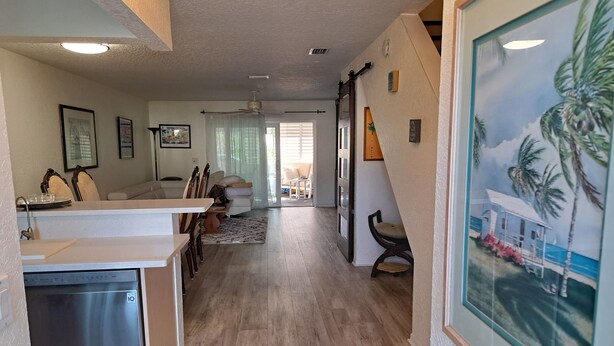 A spacious living area with a dining table, chairs, and a kitchen area with a dishwasher.