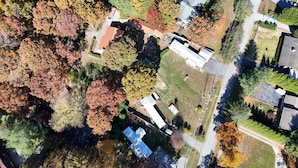Vista aérea de una zona residencial con casas, césped y árboles con hojas otoñales.