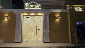 Entrada de un hotel con un cartel que dice "The Heavenly Pyramid".