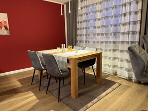 Enjoy meals in this stylish dining area with a table for four, a vase with a flower arrangement, and a cozy atmosphere.