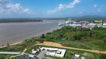 Ein Industriehafen mit Containern, Kränen und einer großen Wasserfläche.