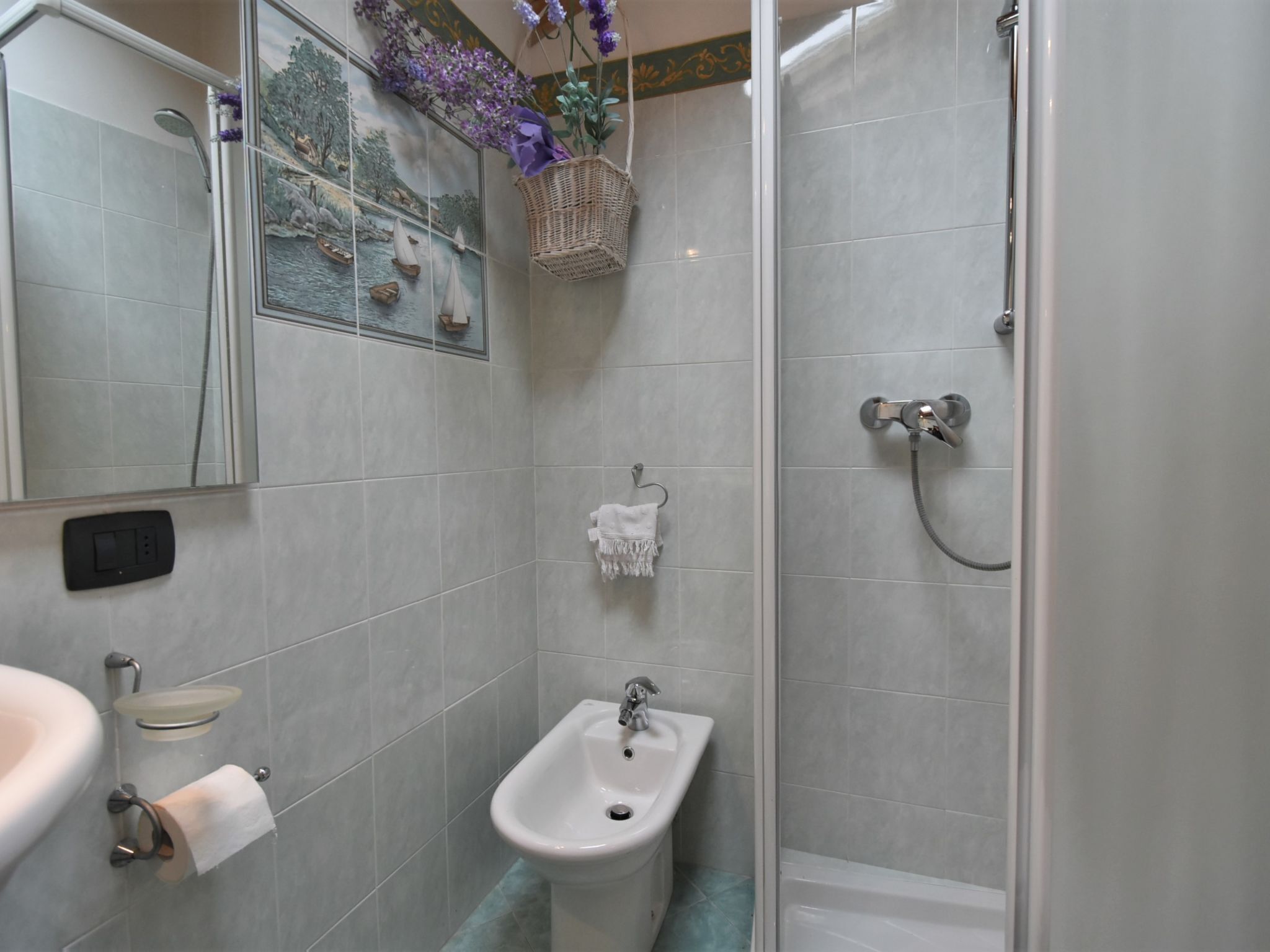 A bathroom with a shower, bidet, and sink.