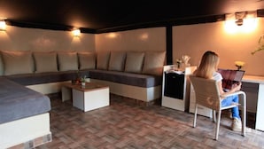 A modern living room with a sofa, a coffee table, and a desk area. - The Farm Lodge & Spa (Marrakech)