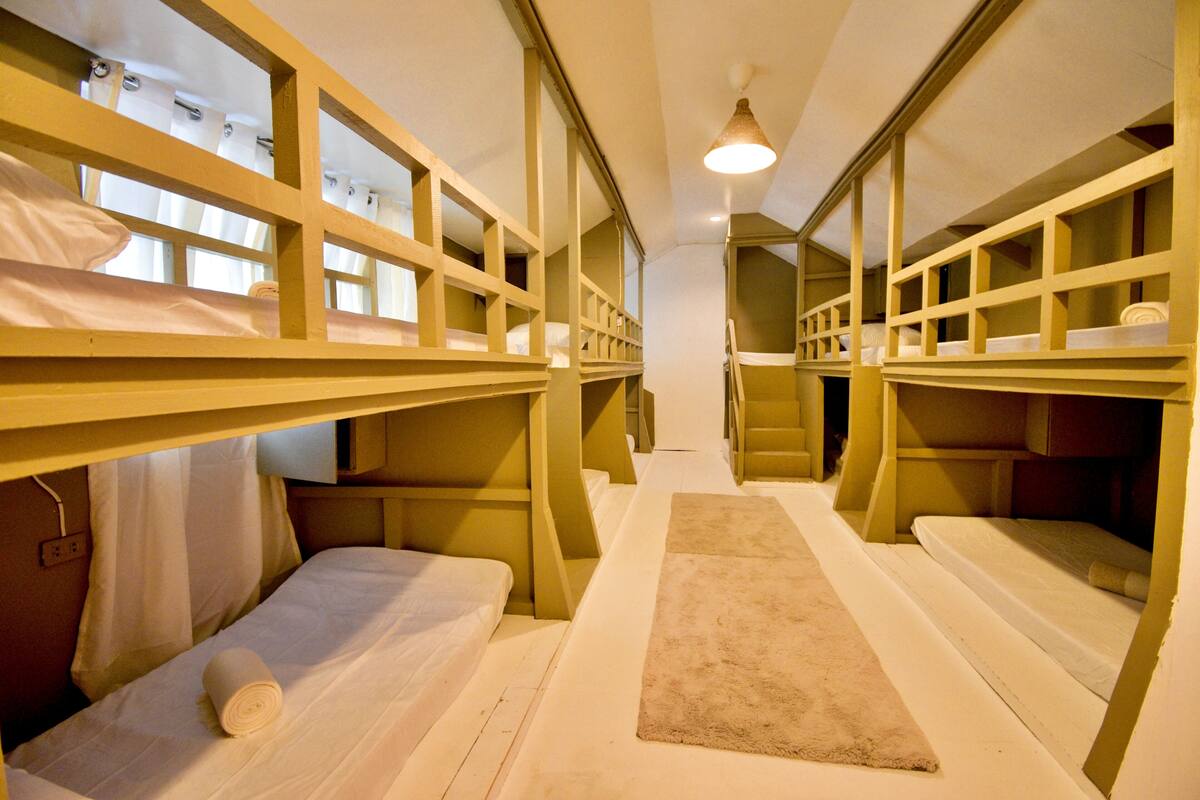 Quarto com beliche, piso coberto por carpete e iluminação no teto.
