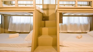 A bunk bed room with a central staircase, white bedding, and curtains. - Treasure Isle Backpacker's Hostel (Boracay Island)