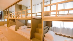 A room with bunk beds, a staircase, and a large mirror. - Treasure Isle Backpacker's Hostel (Boracay Island)