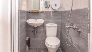 A modern bathroom with a white sink, toilet, and shower. - Quy Hoa Hotel (Xuan Huong - Da Lat)