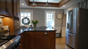 A kitchen with wooden cabinets, a stainless steel refrigerator, and a gas stove. - 5 minute walk to Beach, Stage Fort Park, and Gloucester Promenade! (Gloucester)