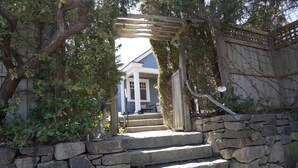 A stone staircase leading to a wooden pergola with a view of a house. - 5 minute walk to Beach, Stage Fort Park, and Gloucester Promenade! (Gloucester)