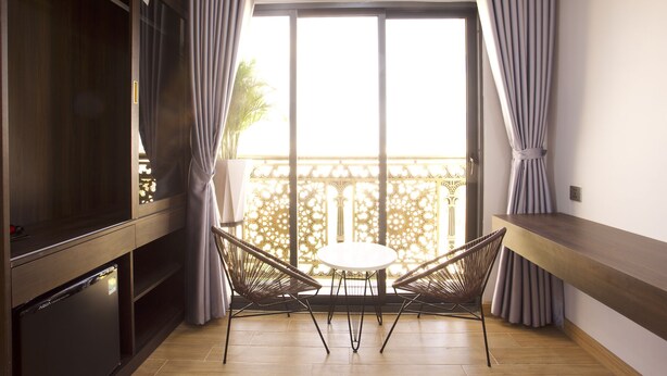 A balcony with a dining table and chairs, a television, and a wooden cabinet. - Uyên Phương Hotel Nha Trang (Nam Nha Trang)