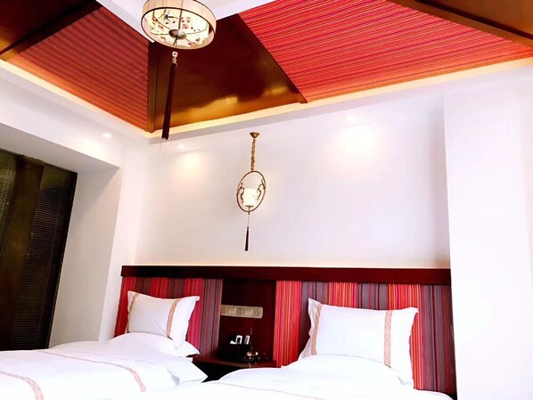 Una habitación de hotel con una cama grande, un ventilador de techo y una araña.