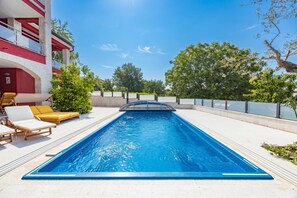 A rectangular swimming pool with a clear blue water surface, surrounded by a white tiled deck. - Apartment Ayni With Private Pool (Umag)