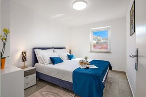 A bedroom with a bed, bedside table, lamp, window, and a view of the outside. - Apartment Ayni With Private Pool (Umag)