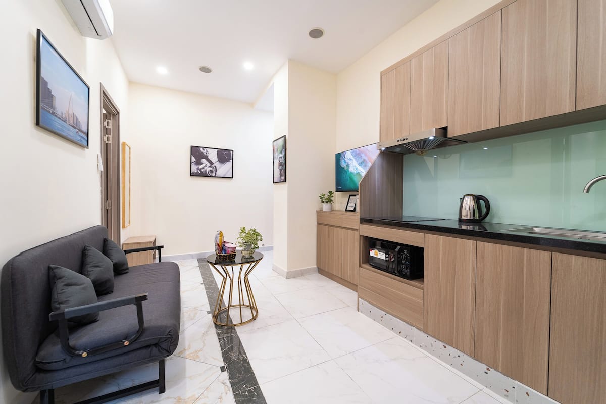 A modern kitchen with wooden cabinets, a black countertop, and a built-in oven.