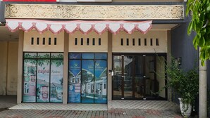 A building with a tiled entrance, large glass windows, and a decorative awning. - SPOT ON 3859 Sweet Candy 2NearResinda park mall (Karawang)