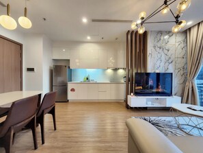 Deluxe appartement | Woonruimte | Een 55-inch flatscreentelevisie met kabelzenders