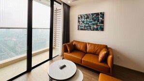 Una sala de estar moderna con un sofá de cuero, una mesa de centro redonda y un ventanal con vistas a la ciudad.