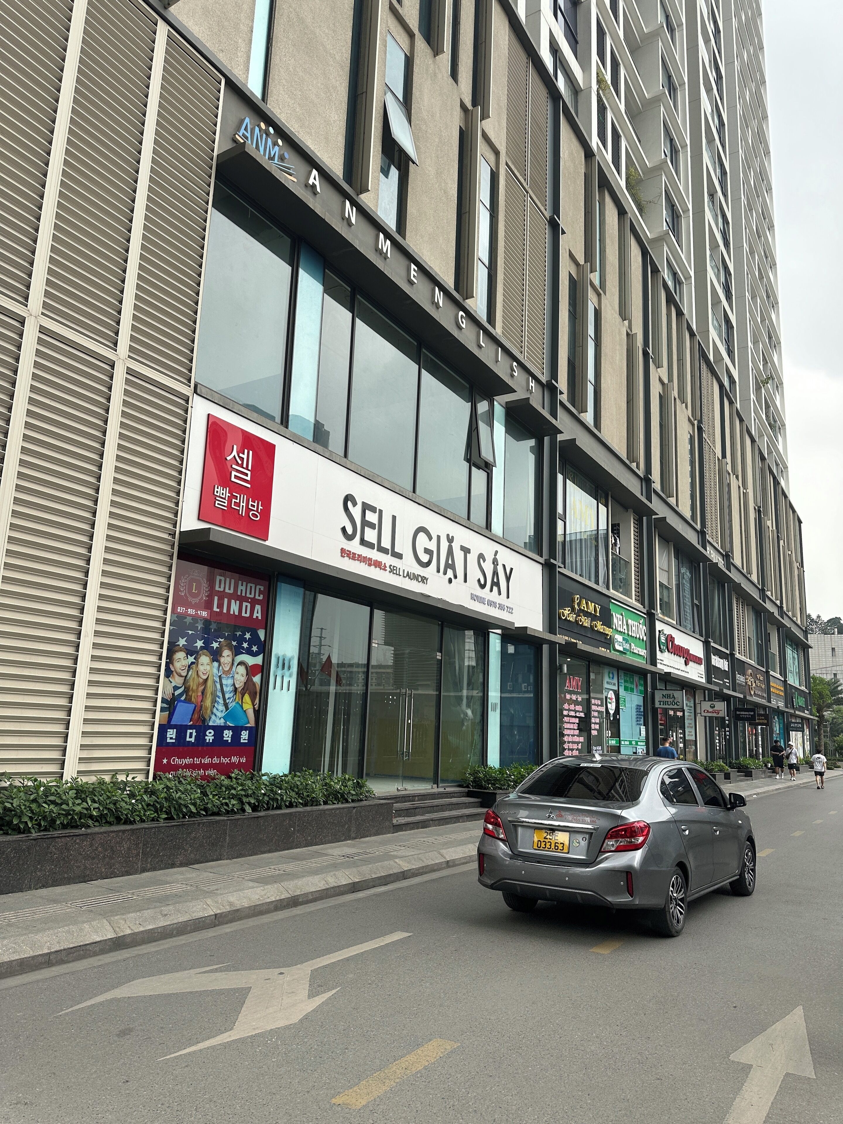Ein Geschäftsgebäude mit verschiedenen Schaufenstern, darunter ein Schild mit der Aufschrift 'SELL GIAT SAY'.