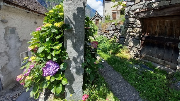 A narrow stone pathway leading to traditional stone buildings with a mountain backdrop. - "Casa Coerente" Cavergno - Rooms #1-4 (Cavergno)