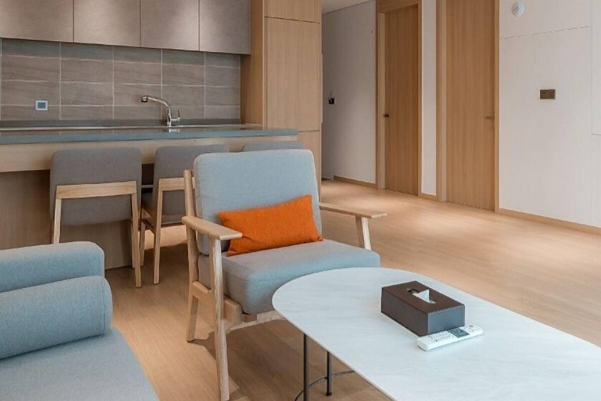 A modern, minimalist living room with a sofa, armchairs, and a coffee table.