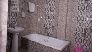 A bathroom with a bathtub, a sink, and a shower. - HOTEL MAHAMAYA PALACE (Deoghar)