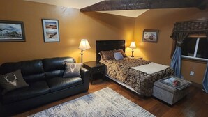 Un dormitorio acogedor con cama, sofá y dos lámparas de noche.