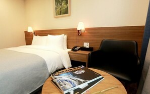 A hotel room with a bed, two bedside lamps, a chair, a nightstand with a phone, and a magazine on the table. - Ramada by Wyndham Gangwon Taebaek (Taebaek)