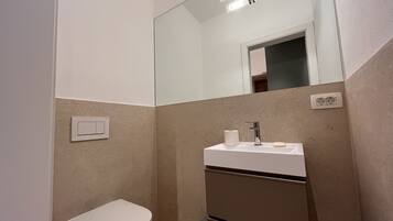 Un baño pequeño con inodoro, lavabo y espejo.