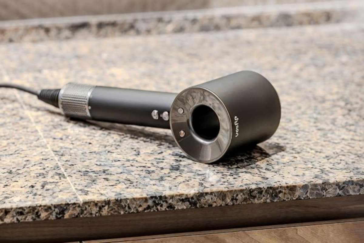 A cylindrical object with a metallic end and a cable, placed on a granite countertop.