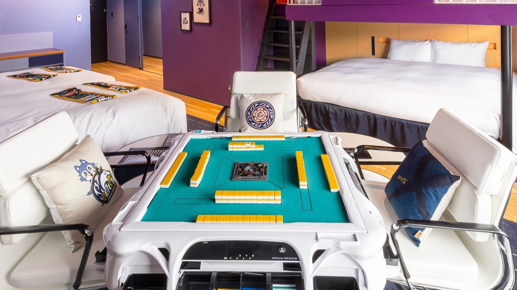 A hotel room with two beds, a desk with a board game, and a chair with a pillow.