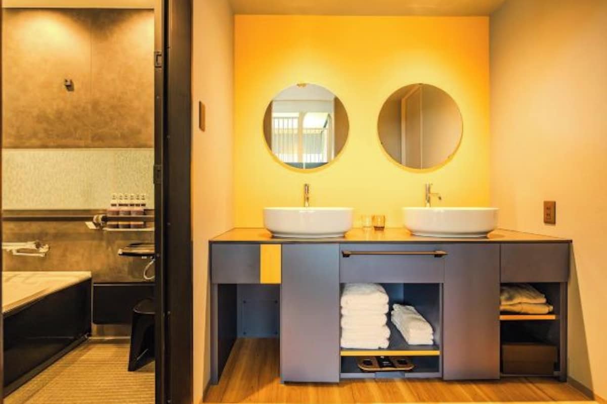 A modern bathroom with two sinks, a towel rack, and a mirror.