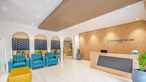 A hotel lobby with a reception desk, blue seating area, and a modern design. - SAPPHIRE BLISS HOTEL (Hyderabad)