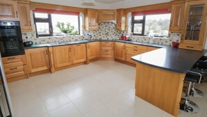 Una cocina moderna con gabinetes de madera, encimera negra y una isla grande.