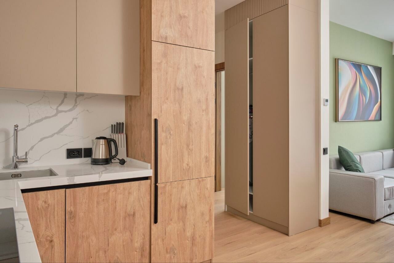 A modern kitchen with wooden cabinets, a marble backsplash, and a coffee maker on the counter.