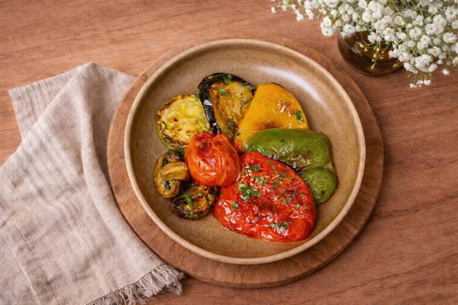 A plate of roasted vegetables on a wooden table.